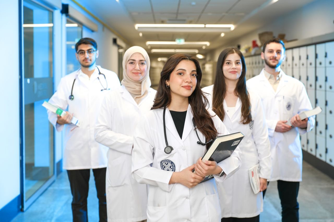 programs-02 Group of diverse medical students wearing lab coats in university corridor, representing future healthcare professionals.